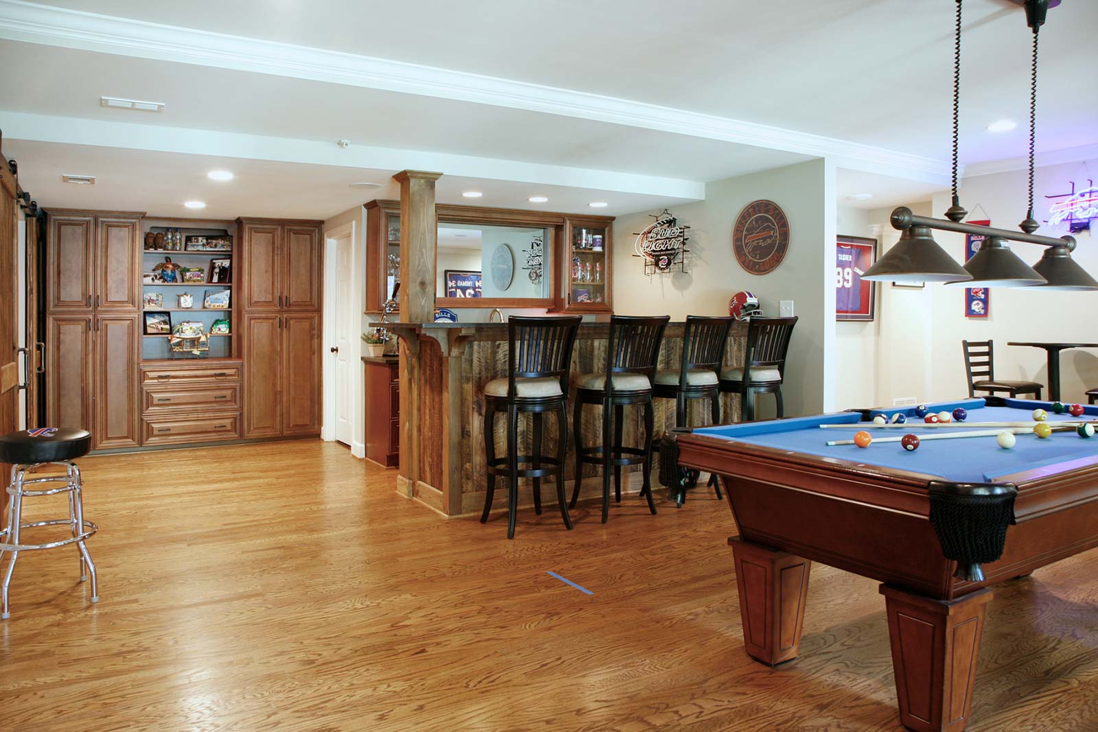 View across gameroom to basement bar with rustic wood front