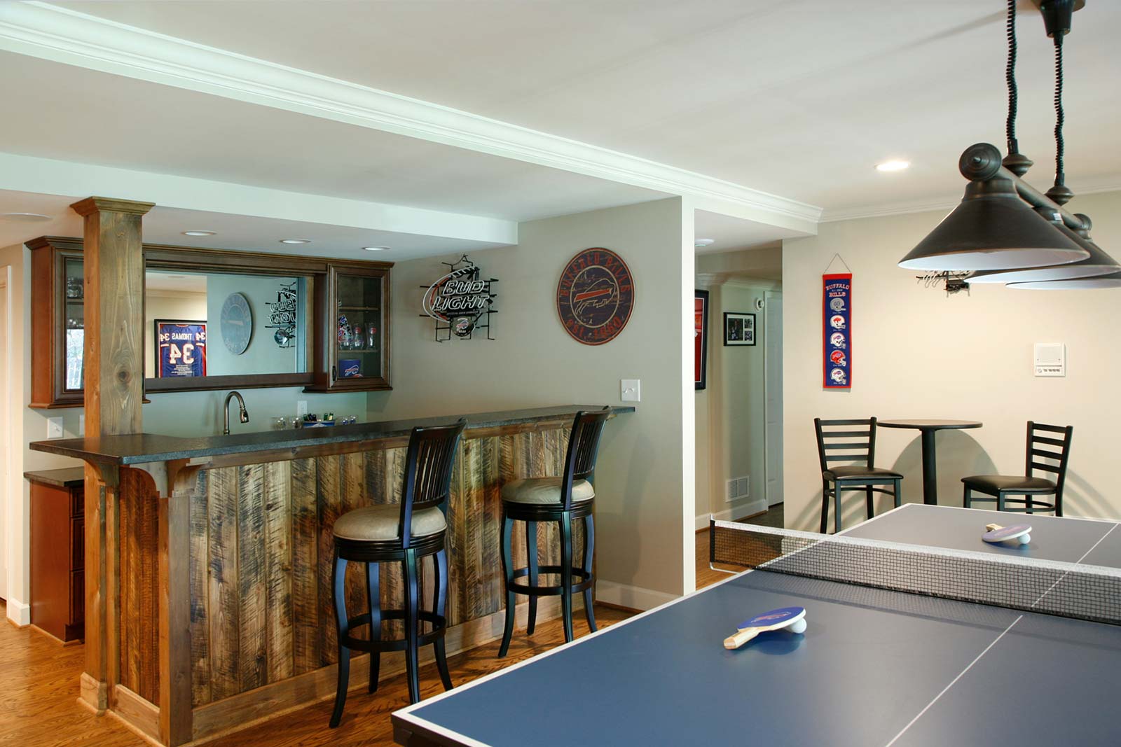 Second view of basement bar with rustic wood front