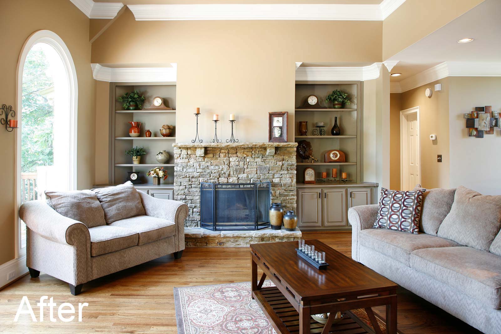 Living room remodeled with rustic stone fireplace and built-in bookcases